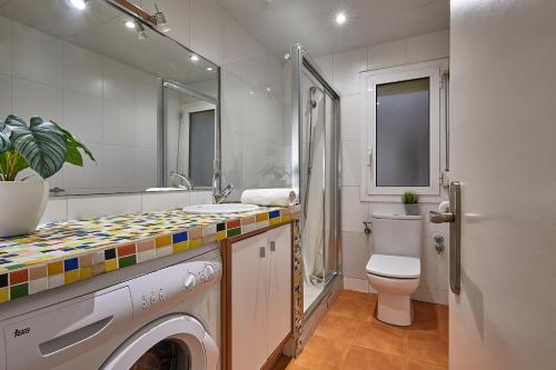 a bathroom with a washing machine and a toilet at BBarcelona Gracia Flat in Barcelona