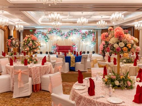 a banquet hall with white tables and chairs and flowers at Hilton Mumbai International Airport Hotel in Mumbai