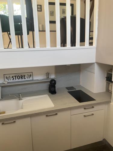 une cuisine avec un évier et un placard dans l'établissement Charmant gîte avec extérieur et piscine partagée, à Mespaul