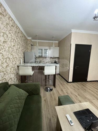 Il comprend un salon avec un canapé et une cuisine. dans l'établissement Tatos Appartments, à Tbilissi