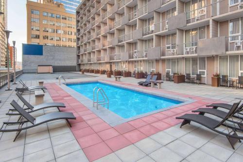 an apartment patio with a swimming pool and chairs at Ramada Plaza by Wyndham Calgary Downtown in Calgary