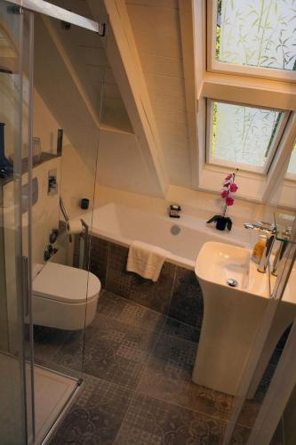 ein Bad mit einem Waschbecken, einem WC und einem Fenster in der Unterkunft Haus Seeblick in Herrsching am Ammersee