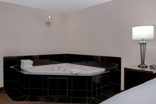 a bathroom with a bath tub with a sink at Ramada Plaza by Wyndham Calgary Downtown in Calgary