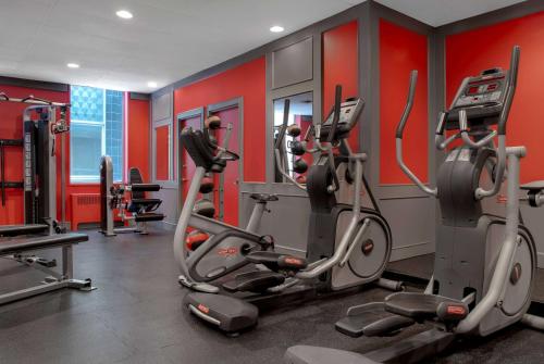 a gym with cardio machines and red walls at Ramada Plaza by Wyndham Calgary Downtown in Calgary