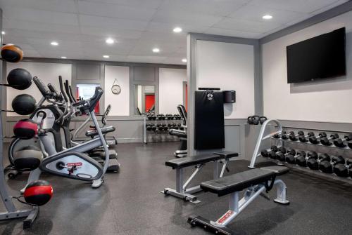 a gym with several tread machines and a flat screen tv at Ramada Plaza by Wyndham Calgary Downtown in Calgary