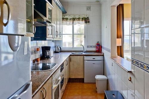 a white kitchen with a sink and a window at Toboso 1 in Nerja