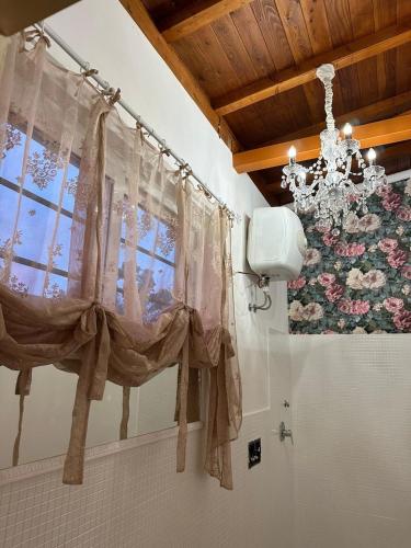 a bathroom with a window and a chandelier at Il Rifugio 1711 in Borgo Vodice