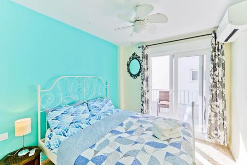 ネルハにあるAcapulco Playaの青いベッドルーム(ベッド1台、天井ファン付)