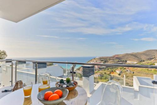a balcony with a table with a bowl of fruit at Casa Grace in Nerja