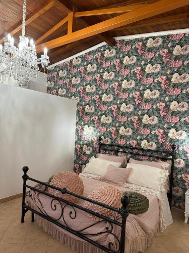 a bedroom with a bed with a floral wall at Il Rifugio 1711 in Borgo Vodice