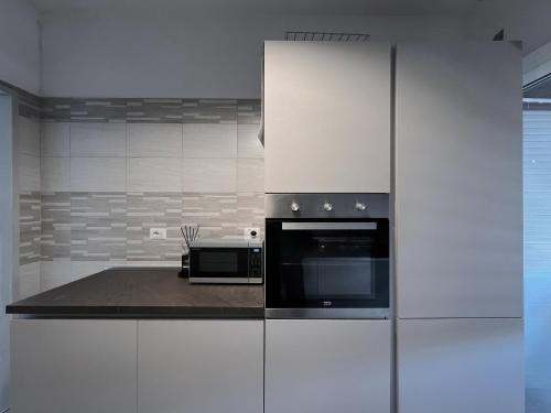 a kitchen with white cabinets and a microwave at Atlantico Apartment in Rome