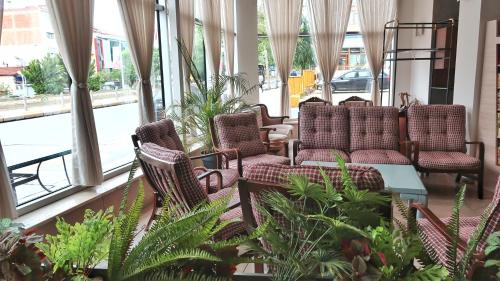 a lobby with chairs and plants and windows at Balta Hotel in Edirne