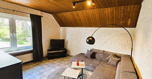 a living room with a couch and a lamp at Übernachten im Café Restaurant Vedder in Herscheid