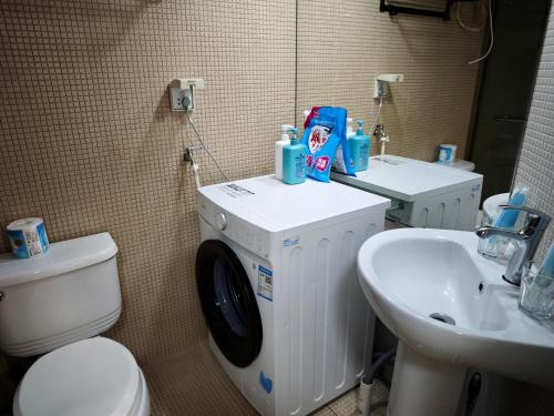a bathroom with a washing machine next to a sink at iNestin Shanghai Apt Hongfeng Road in Shanghai