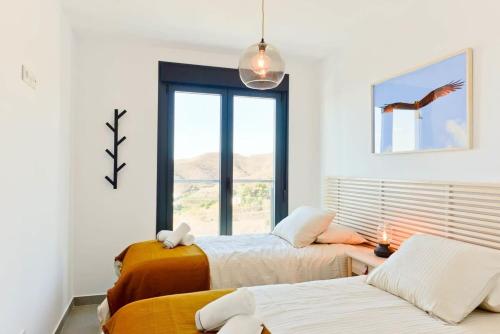 een slaapkamer met 2 bedden en een raam bij Balcon del Mar in Nerja