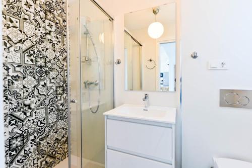 een badkamer met een douche, een wastafel en een spiegel bij Balcon del Mar in Nerja