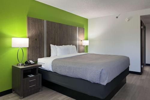 a bedroom with a large bed with a green wall at Quality Inn Clarksville - Exit 11 in Clarksville
