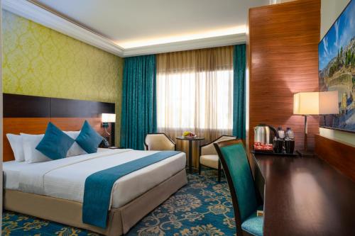 Habitación de hotel con cama y mesa en Corp Amman Hotel, en Amán
