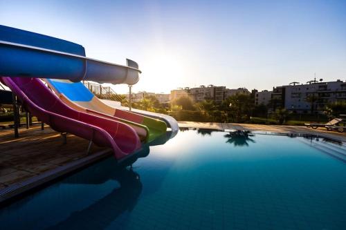 a slide in a swimming pool in a city at Thalassa Beach Resort 2 Bedroom Penthouse with a Hot Tub in Vokolidha