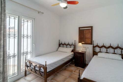 een slaapkamer met 2 bedden en een plafondventilator bij Bellavista 1 in Nerja
