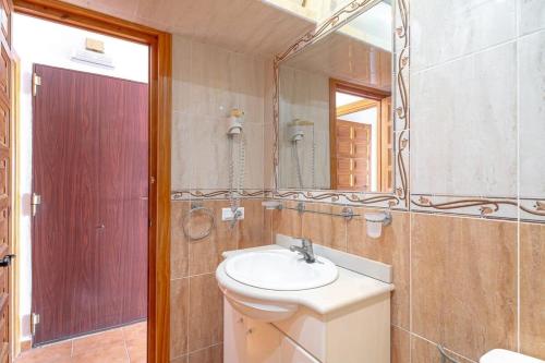 ein Bad mit einem Waschbecken und einem Spiegel in der Unterkunft 19C Las Palmas Oasis de Capistrano in Nerja