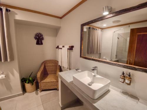 a bathroom with a sink and a mirror at Umbhaba Eco Lodge in Hazyview