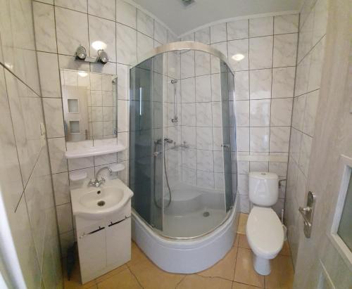 a bathroom with a shower and a toilet and a sink at Pokoje Gościnne Nad Morzem in Łeba