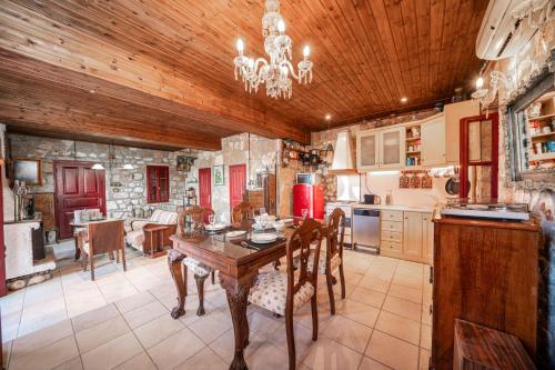cocina con techo de madera y mesa con sillas en NATALIAs MANSION, en Evretí