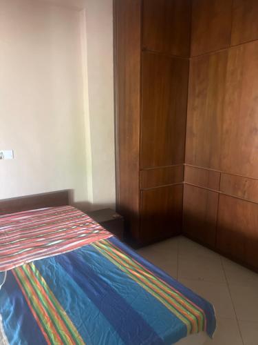 a bedroom with a bed with a colorful blanket on it at Palm Residencies - Rajagiriya in Sri Jayewardenepura Kotte