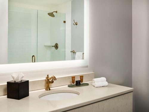 a bathroom with a sink and a mirror at St James Hotel Selma Tapestry Collection by Hilton in Selma