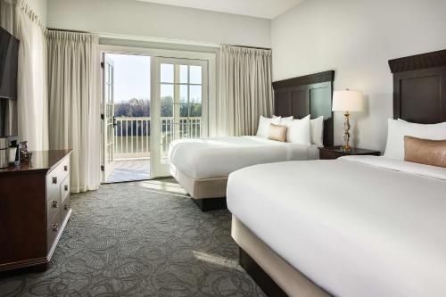 a hotel room with two beds and a balcony at St James Hotel Selma Tapestry Collection by Hilton in Selma