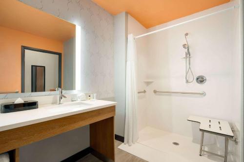 a bathroom with a white sink and a mirror at La Quinta Inn & Suites by Wyndham San Antonio Seaworld LAFB in San Antonio