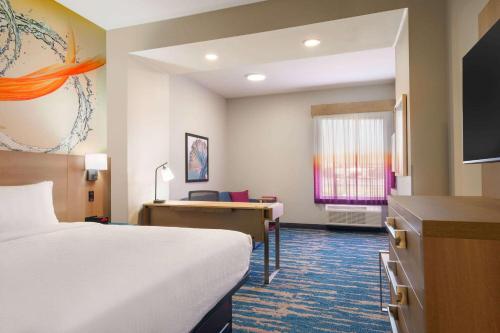 a hotel room with a bed and a desk at La Quinta Inn & Suites by Wyndham San Antonio Seaworld LAFB in San Antonio