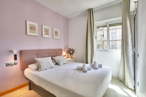 a bedroom with a large white bed with a window at BBarcelona Modern Eixample Flat in Barcelona