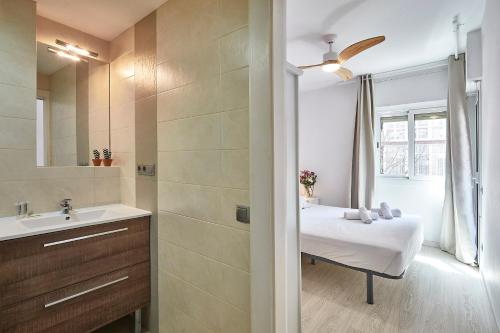 y baño con cama, lavabo y espejo. en BBarcelona Modern Eixample Flat, en Barcelona