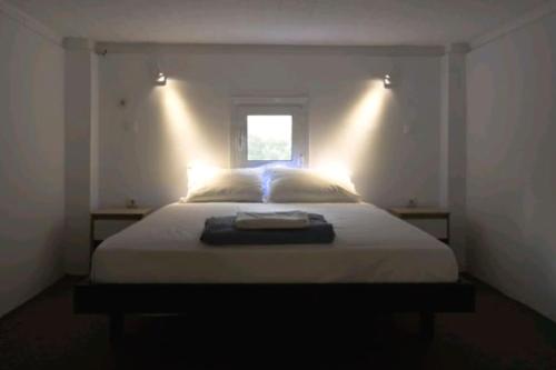 een slaapkamer met een wit bed en een raam bij LoftLiving 1 by ΑΤΤΙΚΟ ΝΟΣΟΚΟΜΕΙΟ in Athene