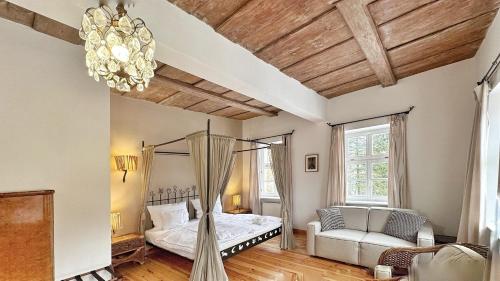 1 dormitorio con cama con dosel y sofá en Klekotki Spa & Resort, en Klekotki