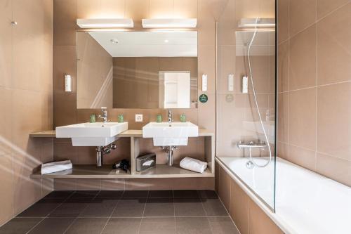 a bathroom with two sinks and a shower at B&B HOTEL Lausanne Crissier in Lausanne