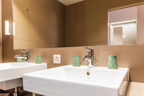a bathroom with two sinks and a mirror at B&B HOTEL Lausanne Crissier in Lausanne