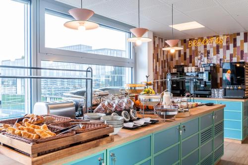 a breakfast buffet with bread and pastries on a counter at B&B HOTEL Lausanne Crissier in Lausanne