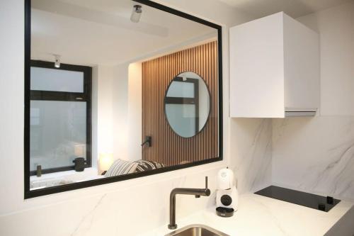 La salle de bains est pourvue d'un miroir au-dessus d'un lavabo. dans l'établissement Logement Idéal en Famille - Porte du Marais - 6P - FLAT-GUEST, à Paris