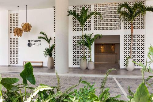 een lobby met palmbomen en planten bij Wyndham Santa Marta Aluna Beach in Santa Marta