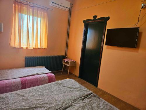 a room with two beds and a flat screen tv at Guljaš Čarda Old in Šupljak