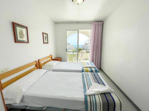 a hotel room with two beds and a window at Apartamentos Font Nova 3000 in Peniscola