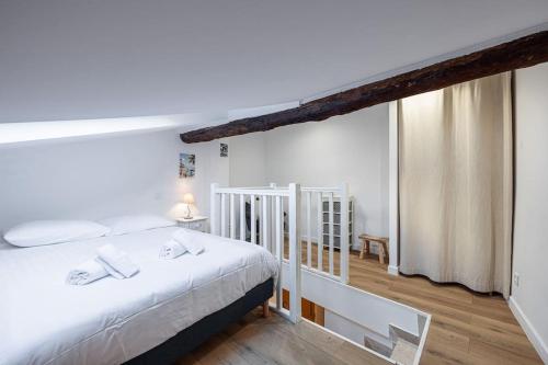 une chambre avec un lit blanc dans une pièce dans l'établissement Magnifique appartement au cœur du Vieux Nice, à Nice