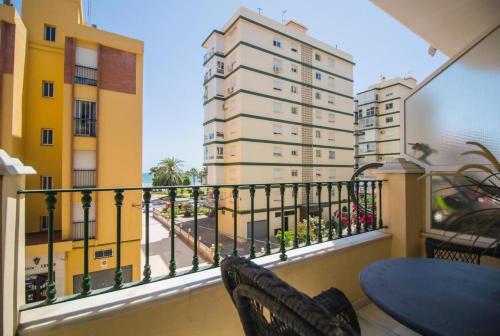 - Balcón con mesa, sillas y edificios en Fabuloso apartamento a 50m de playa centrico, en Torre del Mar