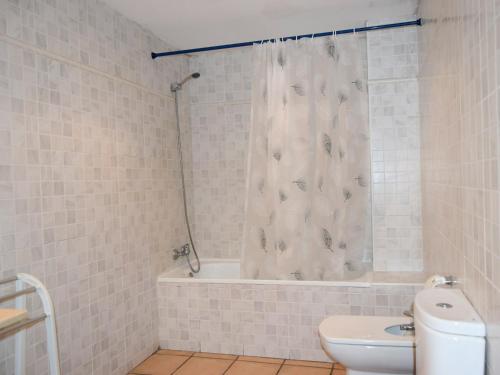 a bathroom with a shower curtain and a toilet at Apartamentos Font Nova 3000 in Peniscola