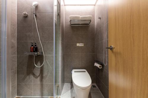 a bathroom with a toilet and a glass shower at Beijing Jingfang Building - Near Tiananmen Square and the Forbidden City,Newly opened hotel in Beijing