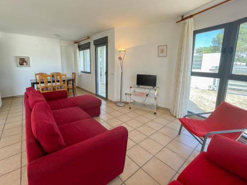 a living room with red couches and a tv at Apartamentos Font Nova 3000 in Peniscola