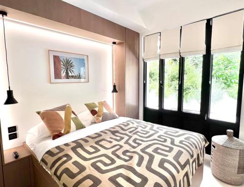 une chambre avec un lit noir et blanc et des fenêtres dans l'établissement Luxueux appartement Cinéma quartier du marais - 8P - FLAT-GUEST, à Paris